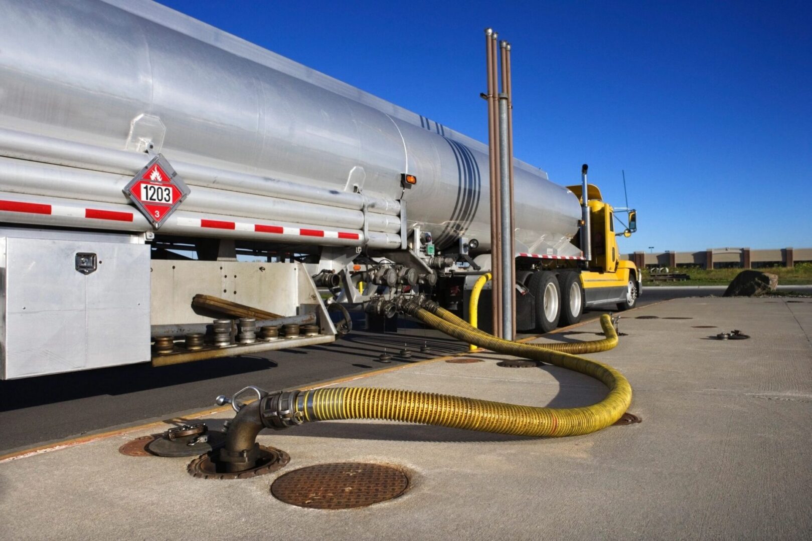 A large truck with a yellow hose attached to it.