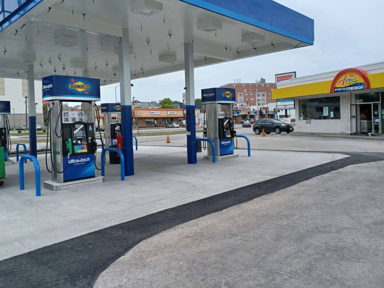 A gas station with several people at the pumps.